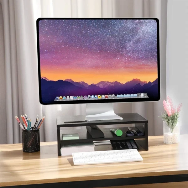 Black two-tier monitor stand raising a screen above a desk with a keyboard underneath